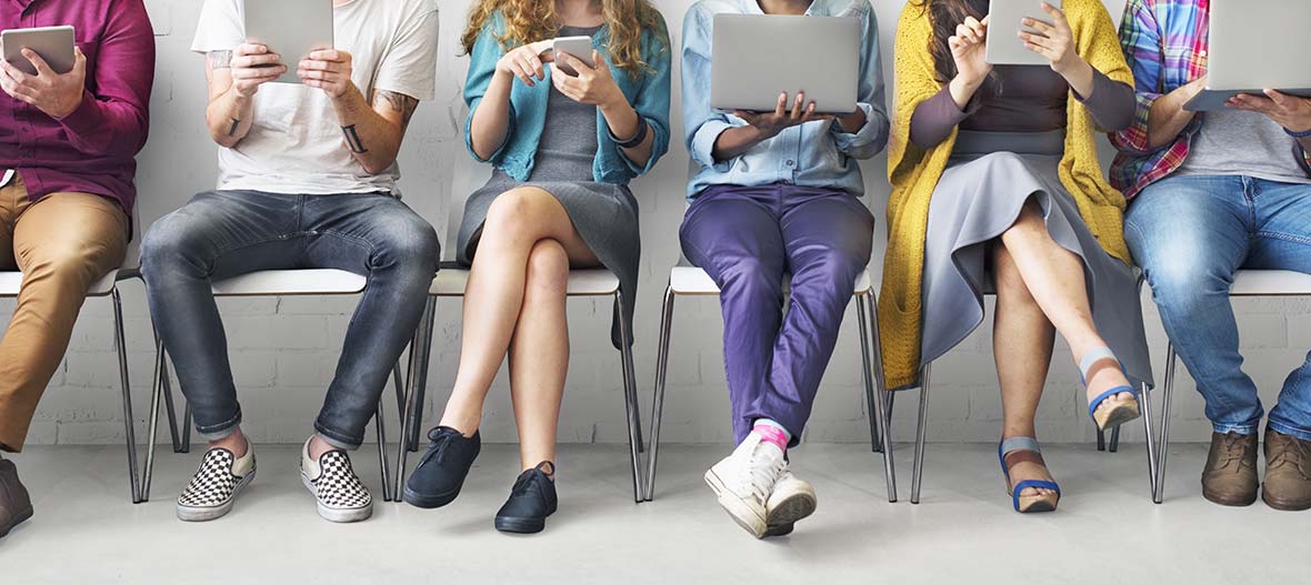 persone sedute con in mano uno strumento di connessione: Gestione social network - Creativi Digitali agenzia di comunicazione digital