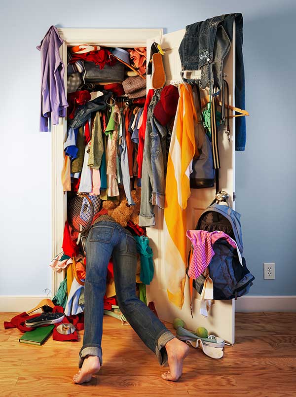 nell'immagine una donna si infila in un armadio pieno di vestiti: ottimizzazione seo per i motori di ricerca - Creativi Digitali