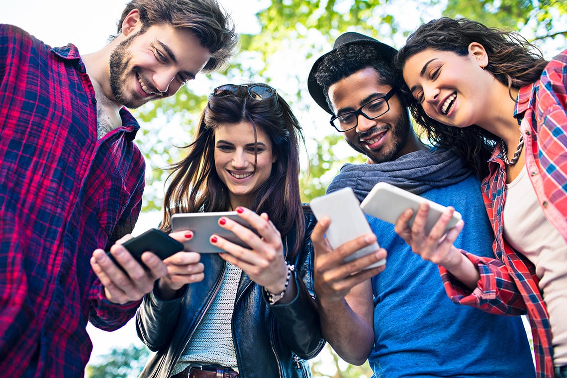 persone guardano il proprio smartphone: social-media-marketing-creativi-digitali-contenuti-ottimizzati-persone-smartphone condivisione