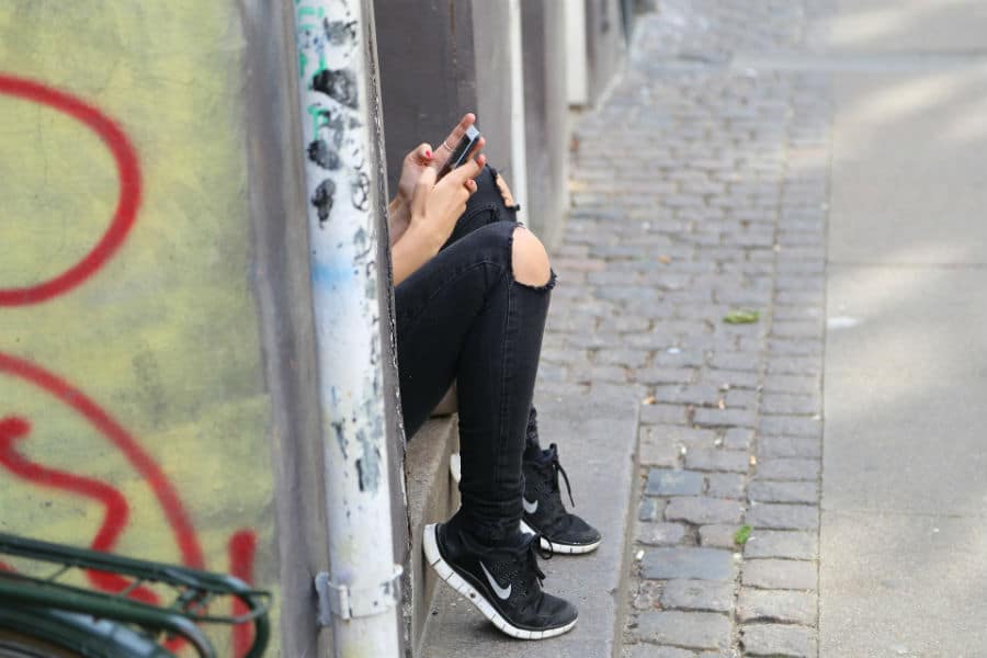 Un adolescente guarda il proprio smartphone