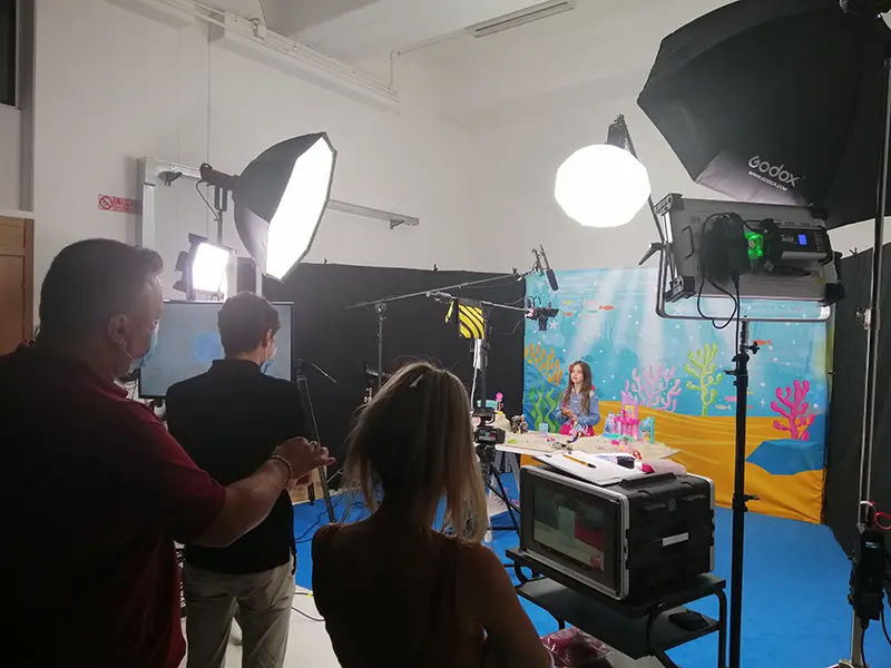 Tecnici e operatori sul set durante una produzione video in diretta