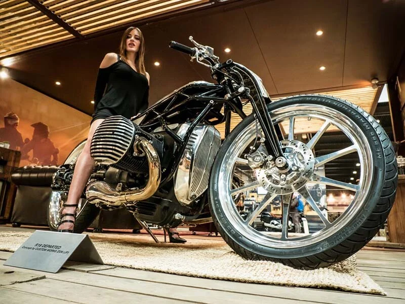 Modella accanto a una motocicletta custom durante un evento
