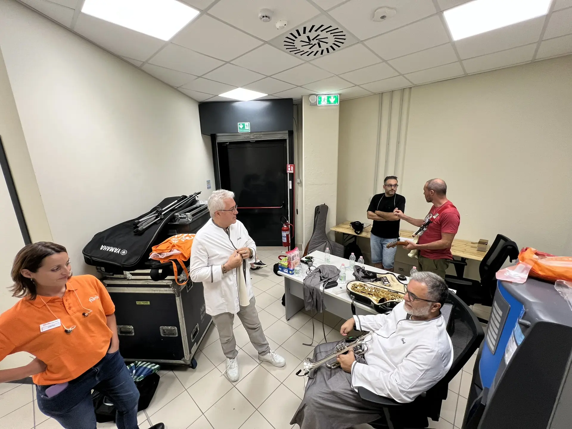 Musicisti e staff nel backstage di una tappa del tour Famila.