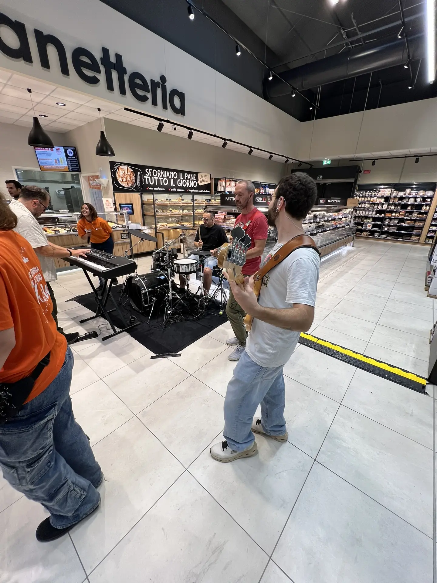 La band suona dal vivo tra i reparti del supermercato.